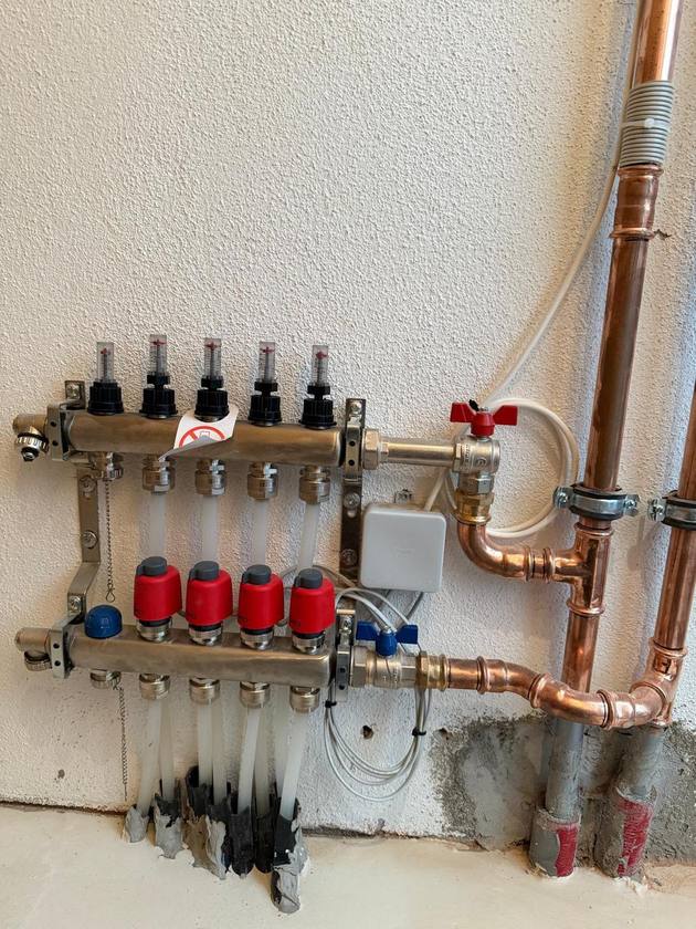 Heizkreisverteiler mit roten Stellantrieben und Kupferleitungen in Stafflangen.
