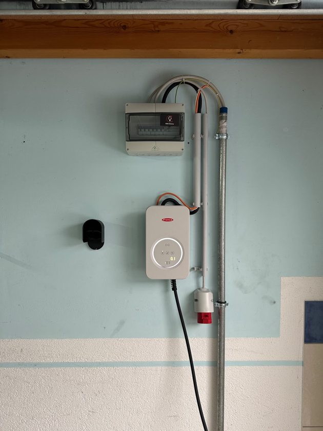 Fronius-Wallbox mit festem Ladekabel, Unterverteiler und roter CEE-Steckdose in einer Garage in Biberach an der Riß.