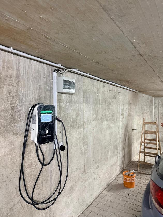 Seitliche Ansicht der Wallbox mit Unterverteiler und Aufputz-Leitungsführung entlang der Tiefgaragenwand in Warthausen.