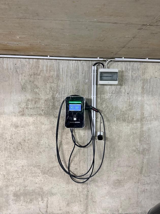 Wallbox mit Ladekabel und Unterverteiler an einer Betonwand in einer Tiefgarage in Warthausen.