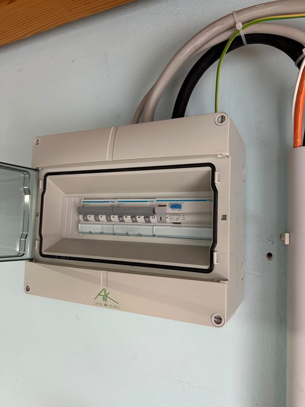 Geöffneter Unterverteiler mit Schutzgeräten und Leitungsanschlüssen für die Installation in der Garage.